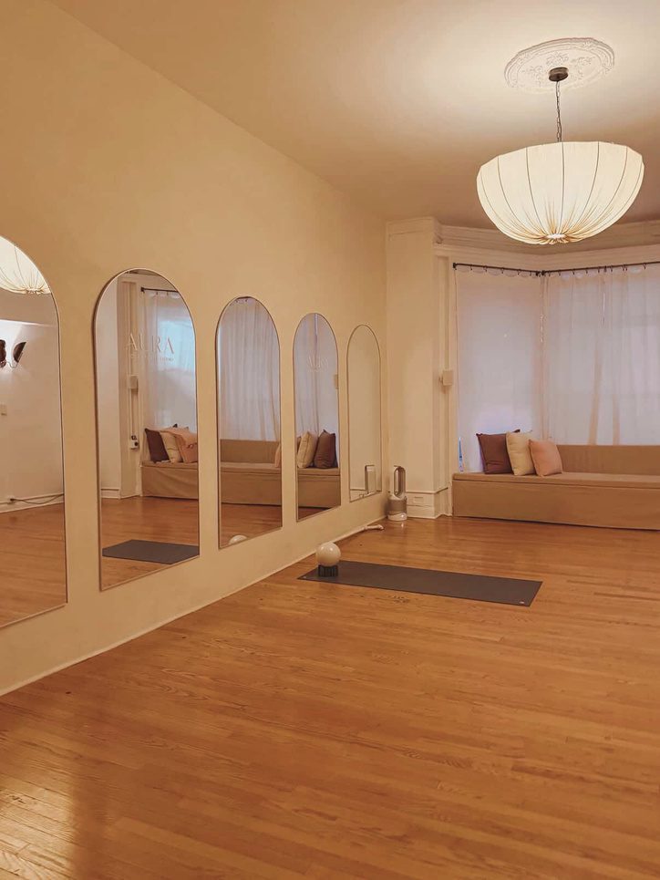 The Atelier room at Aura Studio with arched mirrors, blush cushions and natural light