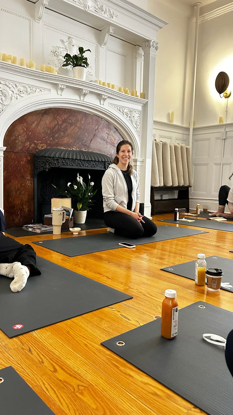 Guests on mats by the fireplace at Aura Studio on the Upper West Side, warm natural light